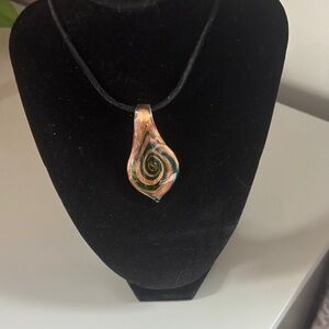 Silver chain and black rope necklace with a unique  gold /green medallion.